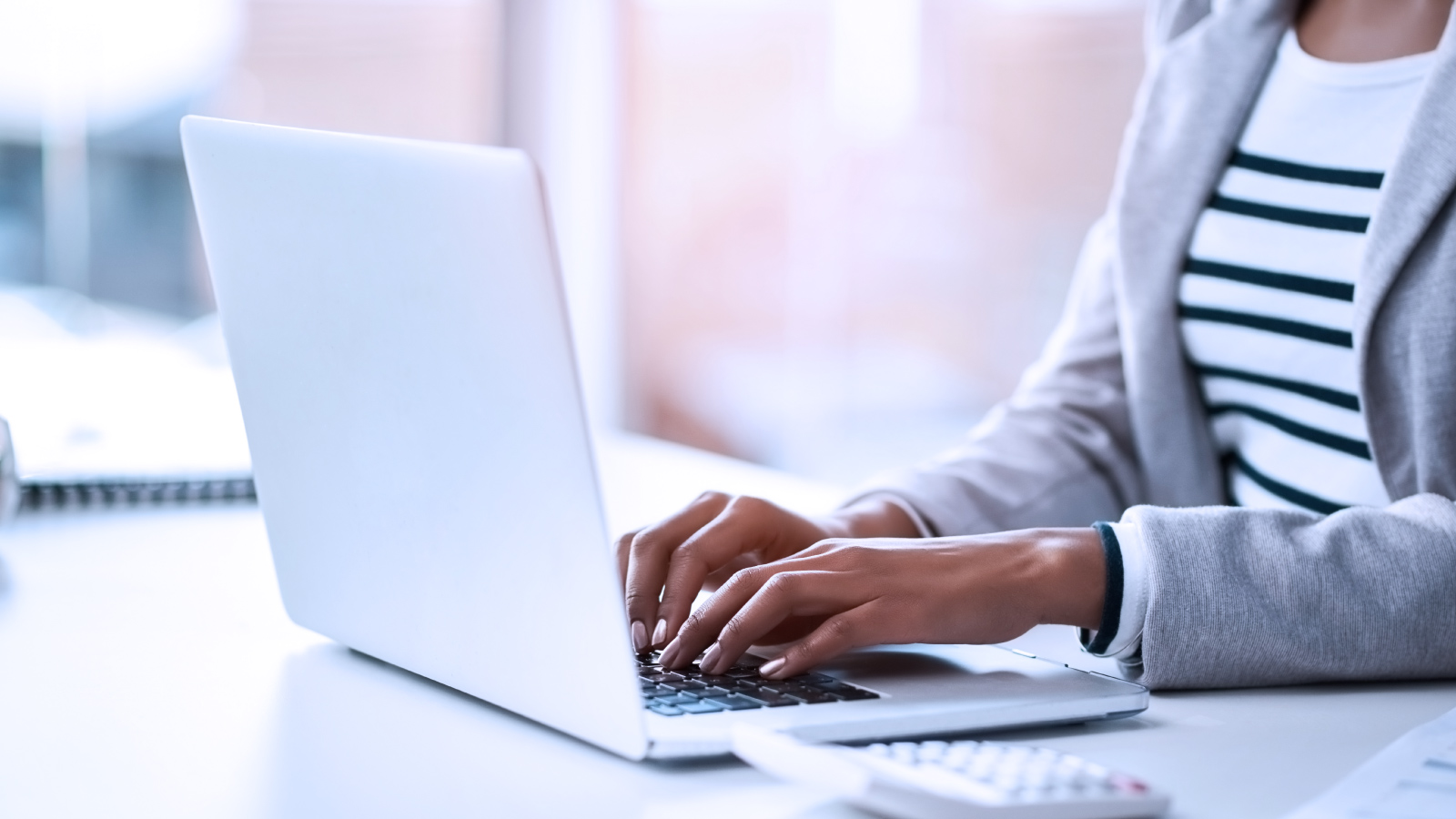 Person at desk typing on laptop