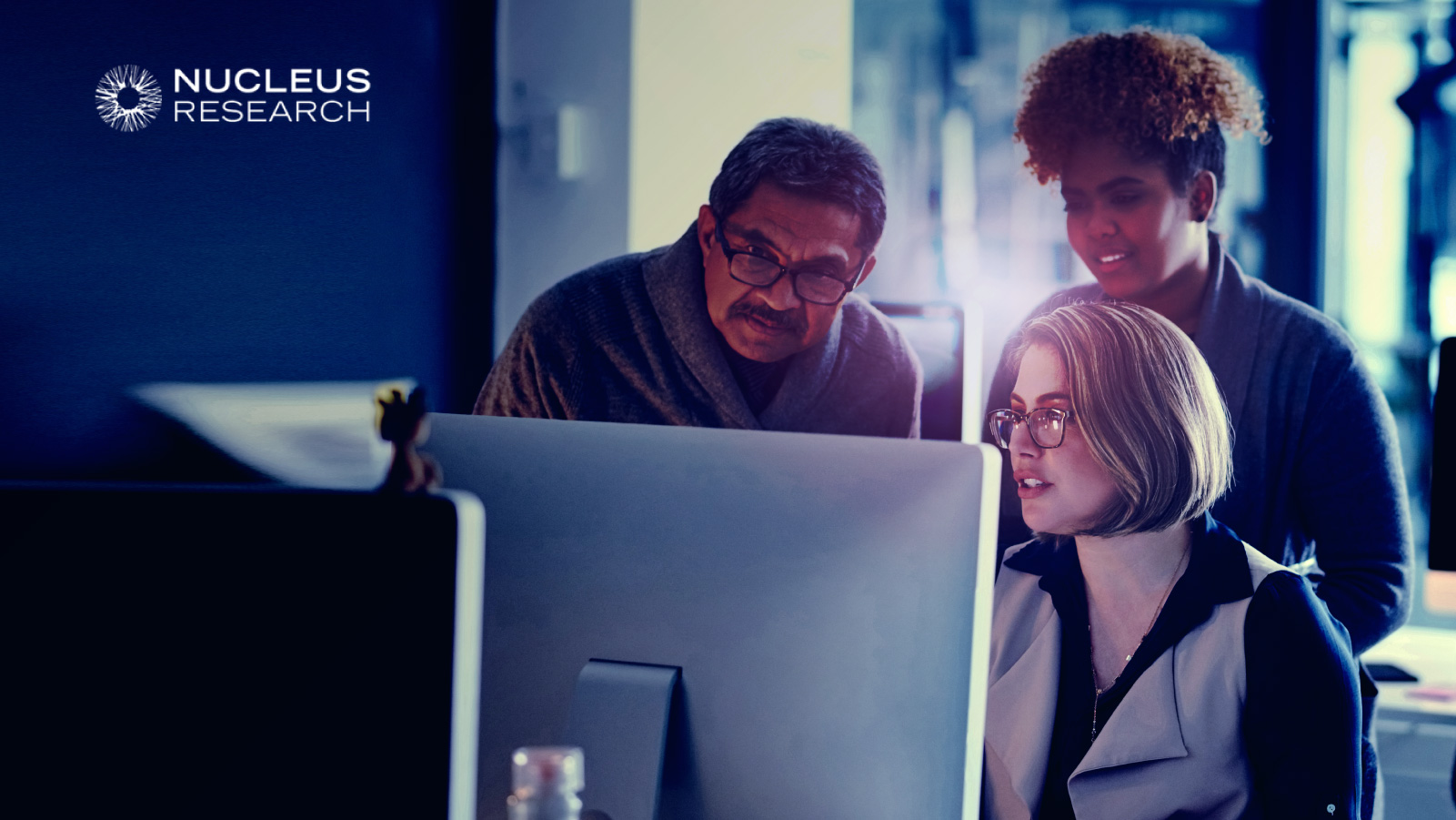 Group of three colleagues reviewing information on a computer