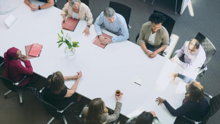 Several colleagues seated around a conference table