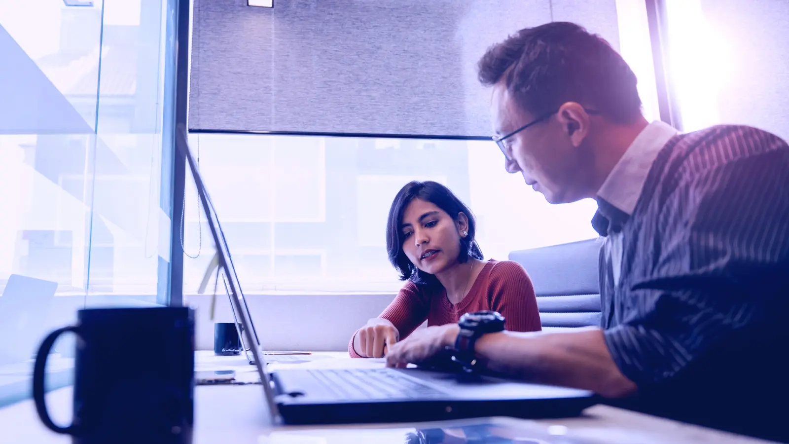Coworkers collaborating over laptop