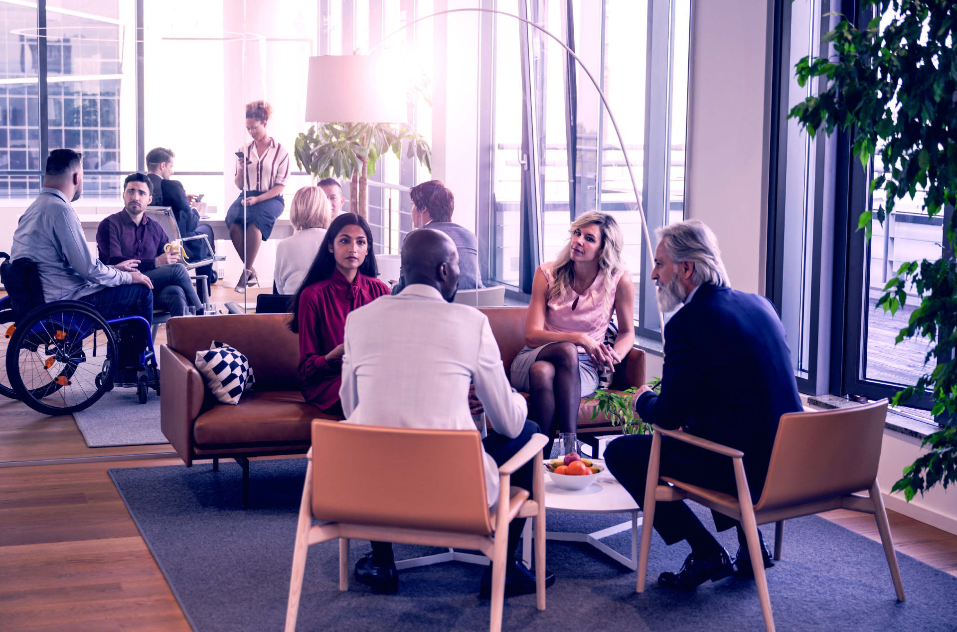 A diverse group of coworkers engaged in a casual meeting in an open floor plan